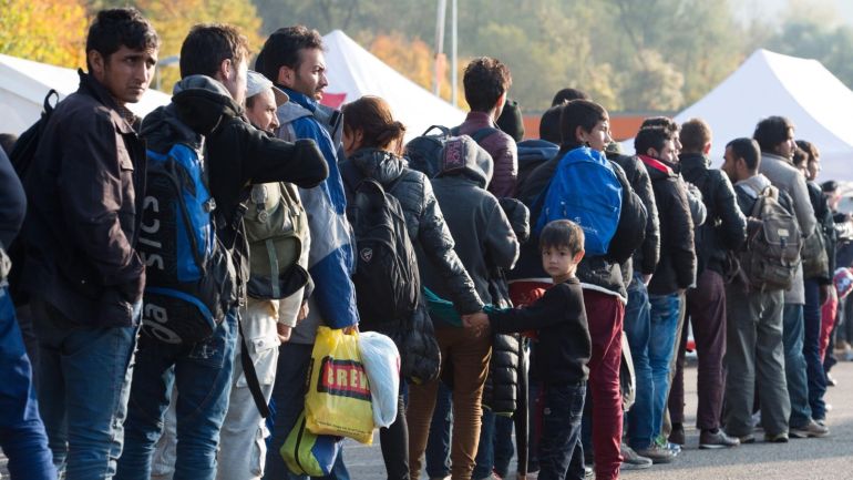 Refugees wait at a inspection station near the Austrian-German border near to Passau, Germany, 30 October 2015. An escalating row in Chancellor Angela Merkel's government over mass arrivals of migrants from war zones provoked a rebuke on 30 October 2015 from German deputy Chancellor Sigmar Gabriel, leader of Germany's Social Democratic Party (SPD). Merkel's September 5 decision to open Germany's borders and absorb migrants has won global praise but local recrimination. The ruling party of southern Bavaria state, the Christian Social Union (CSU), is pressing Merkel's Christian Democrats (CDU) to limit new arrivals. A key bone of contention is a CSU demand for "transit zones" at the Austrian border, analogous to the sealed-off sections of airports where transferring passengers change plane without going through a country's immigration control.