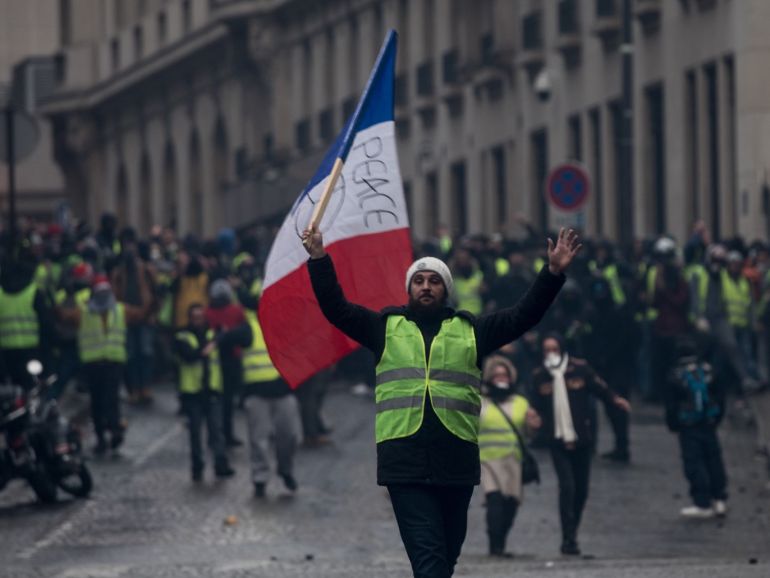 PARIS, FRANCE - DECEMBER 08: Protesters march in the 'yellow vests' demonstration near the Arc de Triomphe on December 8, 2018 in Paris France. ''Yellow Vests' ('Gilet Jaunes' or 'Vestes Jaunes') is a protest movement without political affiliation which was inspired by opposition to a new fuel tax. After a month of protests, which have wrecked parts of Paris and other French cities, there are fears the movement has been infiltrated by 'ultra-violent' protesters. Today's protest has involved at least 5,000 demonstrators gathering in the Parisian city centre with police having made over 200 arrests so far. (Photo by Chris McGrath/Getty Images)