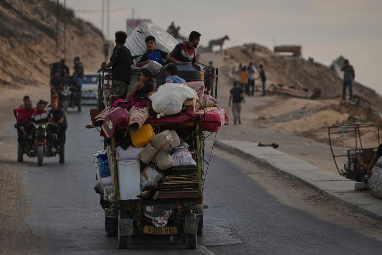 Displaced Palestinians fleeing northern Gaza carry their belongings along the coastal road toward southern Gaza, Saturday, Sept. 6, 2025. (AP Photo/Jehad Alshrafi)