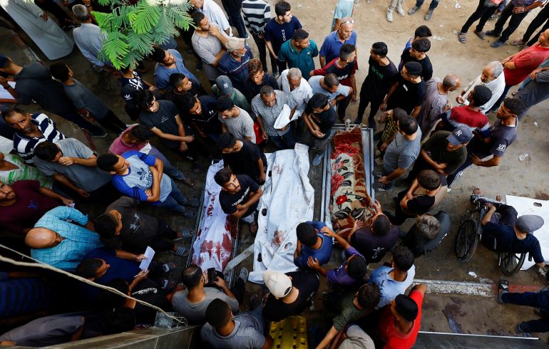 SENSITIVE MATERIAL. THIS IMAGE MAY OFFEND OR DISTURB Mourners stand near the bodies during the funeral of Palestinians killed by Israeli fire while trying to receive aid on Saturday, and others killed in overnight strikes, according to medics, at Al-Shifa Hospital in Gaza City, September 7, 2025. REUTERS/Mahmoud Issa